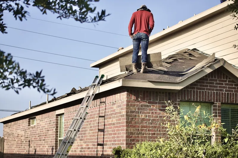 Professional roofer working on a residential roof in Morrell Park